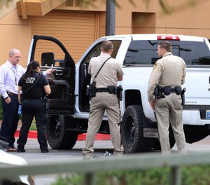 Las Vegas police surround a white pickup truck as they investigate after a pursuit related to the officer-involved shooting that ended at the Golden Nugget hotel-casino on Wednesday, March. 27, 2019, in Las Vegas. (Bizuayehu Tesfaye/Las Vegas Review-Journal via AP)