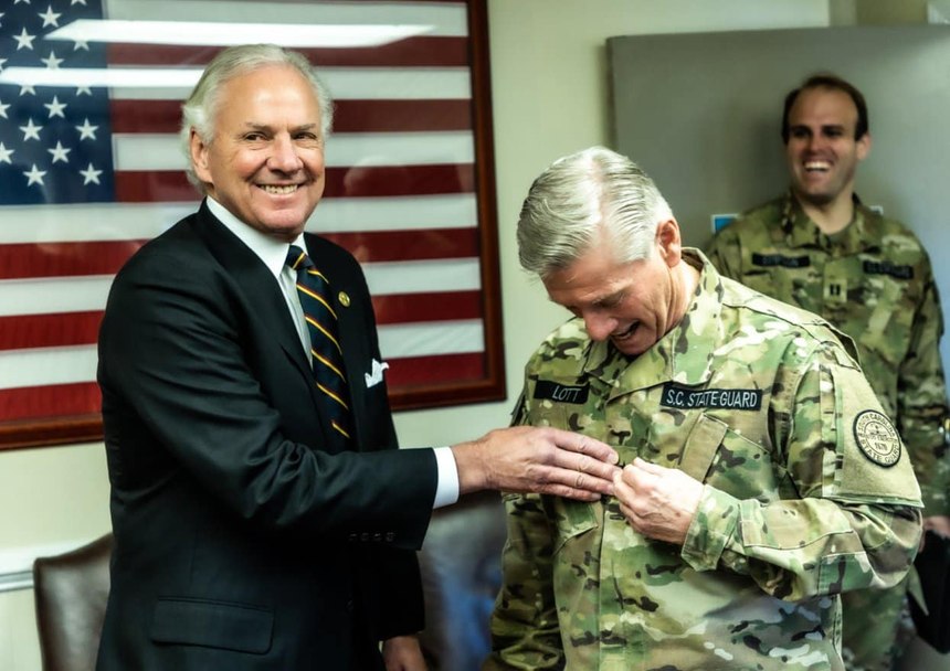 Governor Henry McMaster and Maj. Gen. (Sheriff) Leon Lott share a moment following Lott's promotion ceremony. Looking on is Captain Cody Simpson.