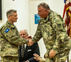 Maj. Gen. Leon Lott (L) is congratulated by Maj. Gen. Van McCarty, adjutant general of S.C., as Governor Henry McMaster looks on.