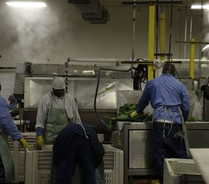 In this April 15, 2014 photo, inmates process freshly harvested greens at the Louisiana State Penitentiary in Angola, La.
