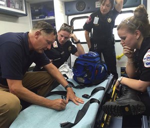 Dr. Rob Dickson and MCHD personnel review a call, using an ambulance as a mobile classroom. (Facebook MCHD)