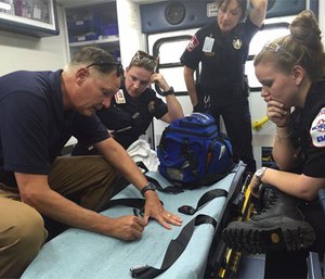 Dr. Rob Dickson and MCHD personnel review a call, using an ambulance as a mobile classroom. (Facebook MCHD)