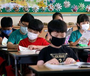 South Korean elementary school students wear masks as a precaution against the MERS, Middle East Respiratory Syndrome, virus as they attend a lesson at an elementary school in Busan, South Korea, Tuesday, June 9, 2015. South Korea is determined to end this week the outbreak of Middle East Respiratory Syndrome, saying upcoming several days will be a critical moment on whether to overcome the medical crisis. (Cha Geun-ho/Yonhap via AP) KOREA OUT