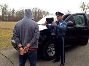 An officer takes a suspect's picture. (Photo courtesy of Mobile Incident Reporting Systems)