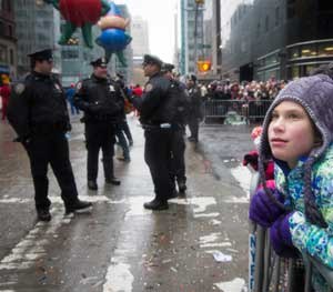 As NYPD officers guard the festivities, a child marvels at the floats and humongous balloons during the Macy's Thanksgiving Day Parade in New York City.