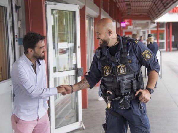 Martin Lazar is pictured talking to a shopkeeper in the local center of the municipality. Criminal activity has has significant implications for the Swedish business community.