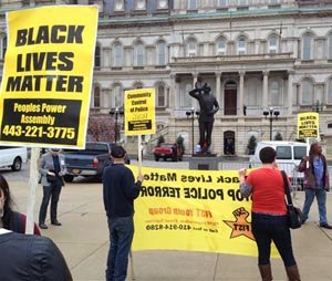 Demonstrators protest the death of Freddie Gray outside Baltimore City Hall on Monday, April 20, 2015. Gray died Sunday, a week after he was rushed to the hospital with spinal injuries following an encounter with four Baltimore police officers. (AP Photo/David Dishneau)