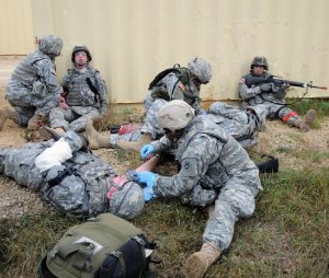 Combat medics treat simulated injured infantry soldiers during a firefight in a village at a Mobile Urban Training Site at Fort McCoy, Wis. The medics had removed the injured soldiers from the line of fire to stabilize them before evacuation. The training was part of pre-deployment medic training.