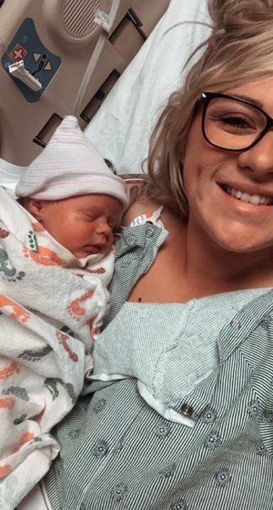 Firefighter Megan Warfield is pictured with her newborn, Charlotte Joan, just 24 hours after assisting fellow victims in a vehicle crash.
