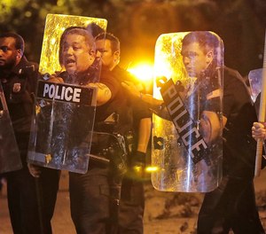 Memphis police brace against the crowd as protesters take to the streets of the Frayser community in anger against the shooting a youth by U.S. Marshals earlier in the evening, Wednesday, June 12, 2019, in Memphis, Tenn. (Jim Weber/Daily Memphian via AP)