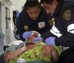 A paramedic holds the hands of a newborn as his colleague attends to the baby's mother, who was evacuated from the maternity and children's hospital in Cuajimalpa, on the outskirts of Mexico City, Thursday, Jan. 29, 2015. The woman give birth to her baby in the ambulance after a powerful gas tank truck explosion shattered the maternity and children's hospital on the western edge of Mexico's capital, killing at least three adults and one baby and injuring dozens. (AP Photo)

