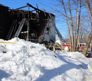 Ground ladders extended to a third floor porch where the captain and a firefighter were removed from the structure.