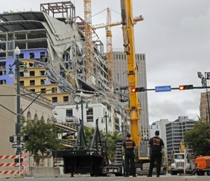 New Orleans Fire Department personnel stand by the scene of the Hard Rock Hotel in New Orleans. (AP Photo/Gerald Herbert)