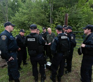 State forest ranger Dan Fox reviews a map with members of the New York State Department of Corrections and Community Supervision emergency response team before entering a wooded area in search of two prisoners who escaped from the Clinton Correctional Facility on Monday, June 8, 2015, in Dannemora, N.Y.