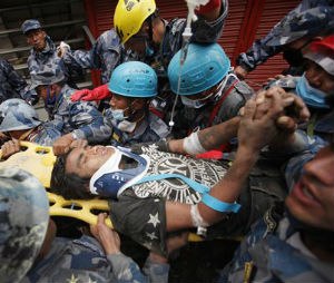 Pemba Tamang is carried on a stretcher after being rescued by Nepalese policemen and U.S. rescue workers from a building that collapsed five days ago in Kathmandu, Nepal, Thursday, April 30, 2015. Crowds cheered Thursday as a Tamang was pulled, dazed and dusty, from the wreckage of a seven-story Kathmandu building that collapsed around him five days ago when an enormous earthquake shook Nepal.