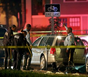 New Orleans Police examine damaged cars and bicycles on Esplanade Avenue in New Orleans after a car struck multiple people, killing several and injuring others following the Endymion Mardi Gras parade on Saturday, March 2, 2019. (Michael DeMocker/NOLA.com/The Times-Picayune via AP)