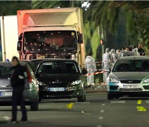 Forensic officers stand near a truck with its windscreen riddled with bullets, that plowed through a crowd of revelers who'd gathered to watch the fireworks in the French resort city of Nice. (AP Photo/Claude Paris)