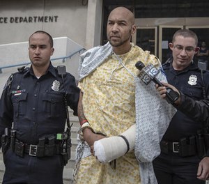 In this Oct. 24, 2015, file photo, Davon Lymon, center, an ex-convict charged in the shooting of an Albuquerque police officer, is escorted by Albuquerque police officers after being released from the hospital in Albuquerque, N.M. (Roberto E. Rosales/The Albuquerque Journal via AP File)