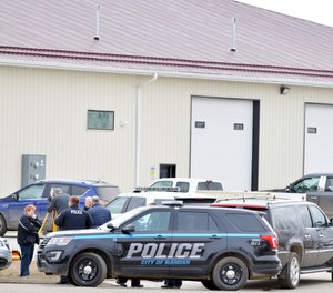 Mandan, N.D. Police Deputy Chief Lori Flaten, left, and other law enforcement personnel stand outside the scene on the south side the RJR Maintenance and Management property in Mandan, N.D., Monday, April 1, 2019. (Mike McCleary/The Bismarck Tribune via AP)
