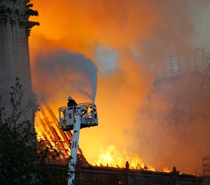 A firefighter douses flames at the Notre Dame cathedral fire in April 2019.
