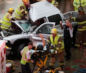 The driver of a truck which crashed during severe weather on Interstate 35 gestures to his rescuers after being cut from the truck in Moore, Okla., Wednesday, May 6, 2015. Forecasters declared a tornado emergency for Moore. (AP Photo/Sue Ogrocki)