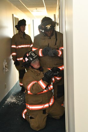 Suppression personnel practicing forcible entry techniques during pre-drill training.