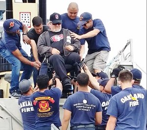 Oakland Firefighters Random Acts volunteers helped to carry wheelchair-bound Veterans at the 2018 Wheelchair Regatta at the Encinal Yacht Club in Alameda. (Photo/courtesy https://www.facebook.com/Oakland-Firefighters-Random-Acts-381744737537/?tn-str=k*F)
