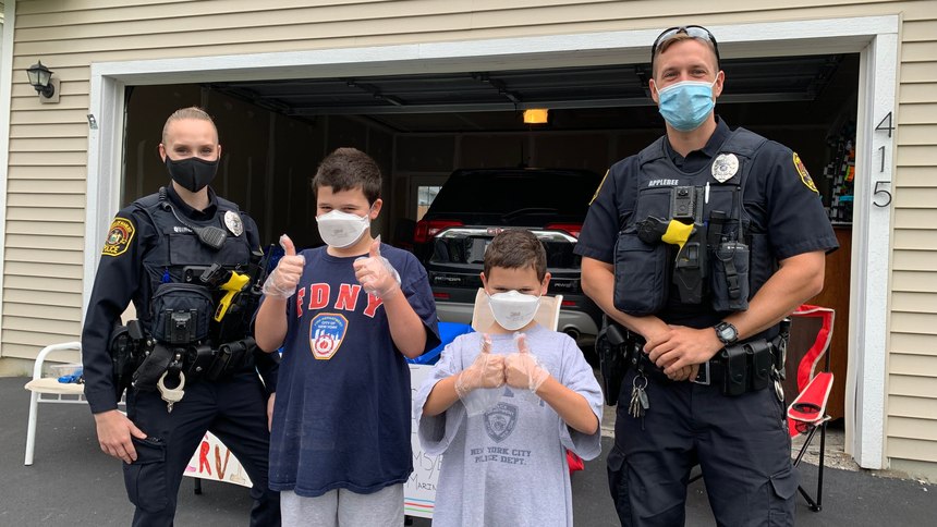 Manilus Police Officer Quinlan (left) and Officer Applebee pose with Isaac (center left) and Benjamin Bloom.
