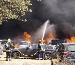 Firefighters respond to a parking lot blaze that destroyed over 400 cars. (Photo/Hugo Teixeira)