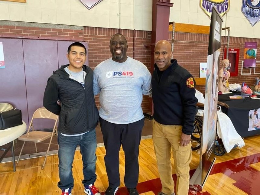 Program participant Abriel Garcia stands with Andre Tiggs (PS419 instructor) and former TFRD Fire Chief Brian Byrd.