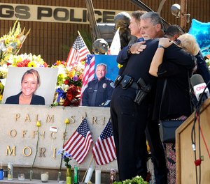 Palm Springs councilmembers Ginny Foat, far right and J.R. Roberts, hug Palm Springs Police Chief Bryan Reyes at the conclusion of a press conference for slain Palm Springs Police Officers Jose "Gil" Gilbert Vega and Lesley Zerebny (AP Photo/Rodrigo Pena)