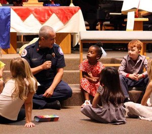 The service was decorated with a vase with flowers and American flags on a table along with a firefighter's helmet, a sheriff's cap and a paramedic's blue pouch. (Photo/ Palm Coast United Methodist Church)
