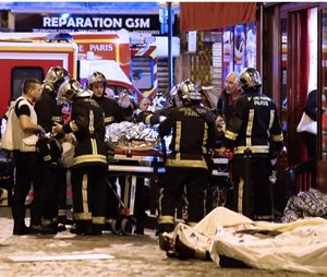 Rescue workers gather at victims in the 10th district of Paris, Friday. (AP Photo/Jacques Brinon)