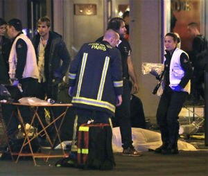 Rescue workers at the scene as victims lay on the pavement outside a Paris restaurant. (AP Photo/Thibault Camus)