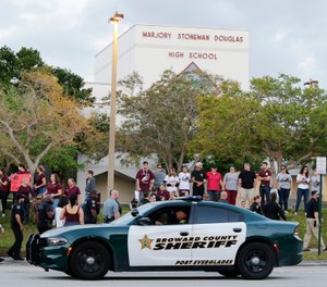 A police car drives near Marjory Stoneman Douglas High School in Parkland, Fla. (AP Photo/Terry Renna)