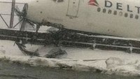 Airliner skids off snowy NY runway, injures 6