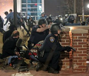 Police take cover after two officers were shot while standing guard in front of the Ferguson Police Station on Thursday, March 12, 2015. (AP Photo/St. Louis Post-Dispatch, Laurie Skrivan)