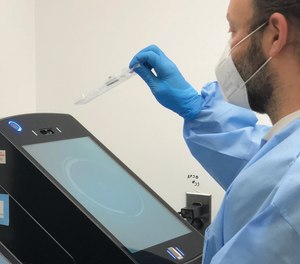 A technician at Philadelphia Police Department's forensic lab analyzes a DNA sample using Thermo Fisher's RapidHIT ID system.