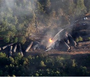 In this June 3, file photo, an oil train burns near the town of Mosier, Ore., after derailing. U.S. safety officials say they've seen slow progress in efforts to upgrade or replace tens of thousands of rupture-prone rail cars. (Alan Berner/The Seattle Times via AP, file)
