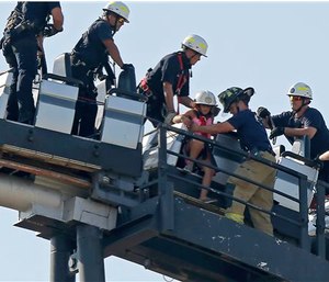 Oklahoma City firefighters rescue amusement park goers from a stalled roller coaster at Frontier City Wednesday. (Bryan Terry/The Oklahoman via AP)