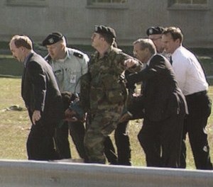 Secretary of Defense Donald Rumsfeld helps carry a patient to an ambulance after the attack at the Pentagon.