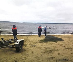 Russian Ministry for Emergency Situations workers stand at the site of an incident, at a lake in Russia's northwestern region of Karelia, Russia. (Russian Ministry for Emergency Situations photo via AP)
