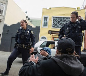 As the police arrive, Seth Carus comforts Bud after his overdose. (Photo/ Tribute News Service, Brian Rinker for Kaiser Health News)