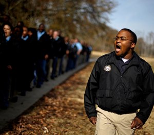 Correctional officer Jarvis Barrion leads a class of new recruits on a march at a training facility in Forsyth, Ga.