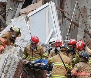 Emergency crews rescue a woman from a building collapse Friday Dec. 2, 2016 in downtown Sioux Falls. Two people were trapped inside the building, which was undergoing construction at the time of the collapse.