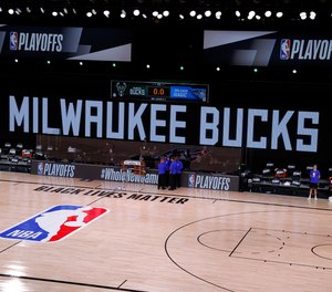 Referees huddle on an empty court at game time of a scheduled game between the Milwaukee Bucks and the Orlando Magic for Game Five of the Eastern Conference First Round during the 2020 NBA Playoffs on Aug. 26, 2020 in Lake Buena Vista, Florida.