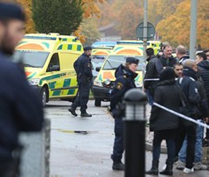 A crowd gathers outside, as emergency services attend the scene of a sword attack by a masked man at a school in Sweden. (Bjorn Larsson Rosvall / TT via AP)