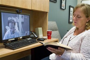 In this Sept. 10, 2014 photo released by the Nebraska Medical Center, Debbie Sacra reads Bible verses to her husband Dr. Richard Sacra via a video link in Omaha, Neb. Dr. Sacra is being treated for ebola at the biocontainment unit at the Nebraska Medical Center in Omaha, Neb. (AP Photo/Nebraska Medical Center, Max Sacra)