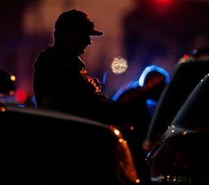 A law enforcement officer mans a barricade near a home that authorities have surrounded where an armed suspect has taken refuge after shooting a Sacramento police officer, Wednesday, June 19, 2019, in Sacramento, Calif. (AP Photo/Rich Pedroncelli)