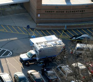 n this Dec. 14, 2012 aerial file photo, officials stand outside of Sandy Hook Elementary School in Newtown, Conn.